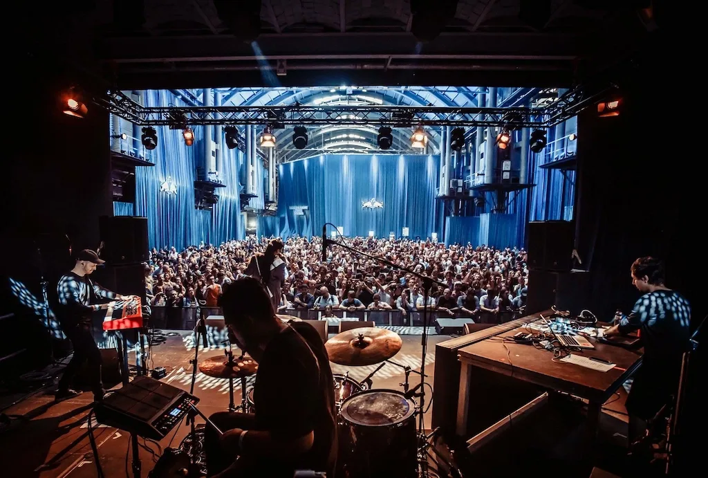 Anthony drumt op een festivalpodium voor een groot publiek